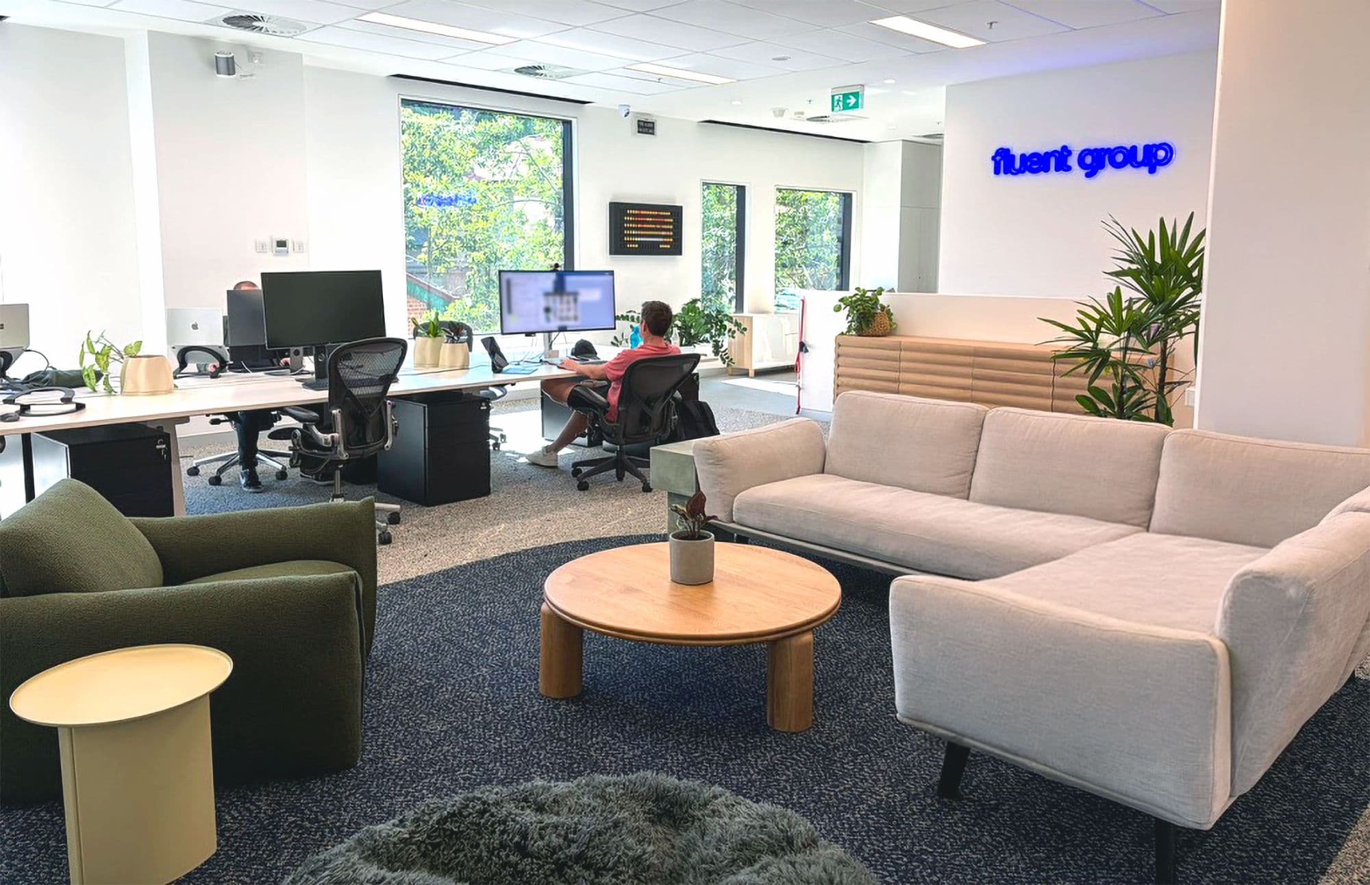 The Brisbane floor on an ordinary afternoon, desks on one side and the lounge on the other