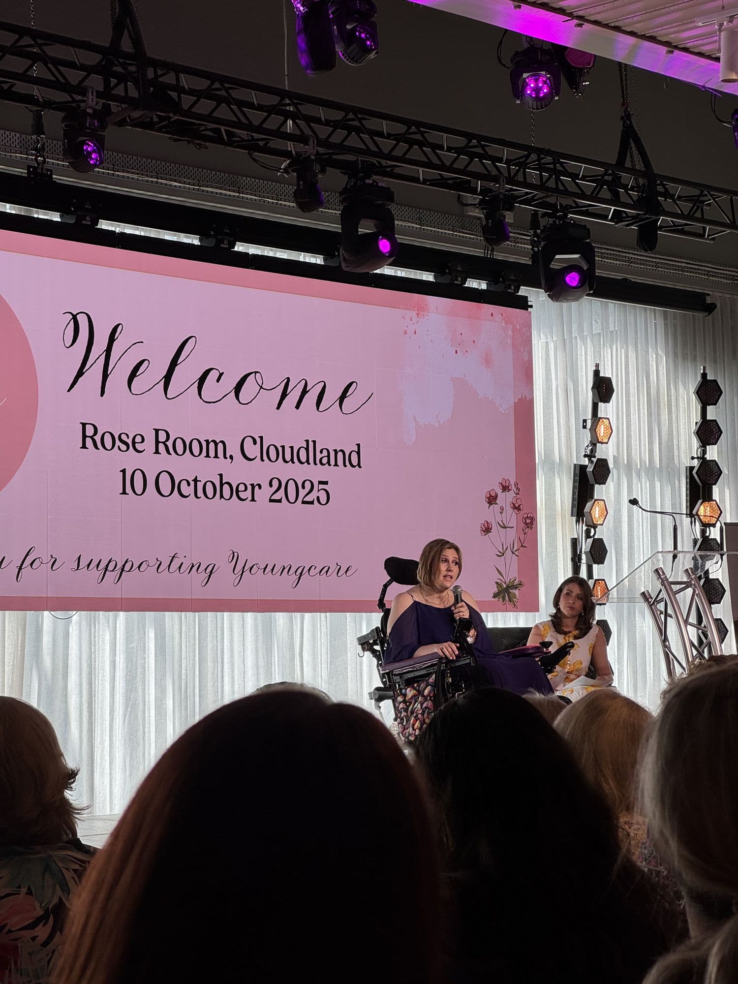 A speaker on stage at the Y Women lunch, addressing the room from her wheelchair