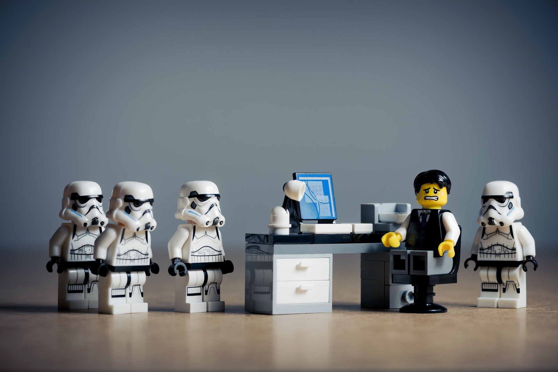 Lego man at a a desk surrounded by storm troopers